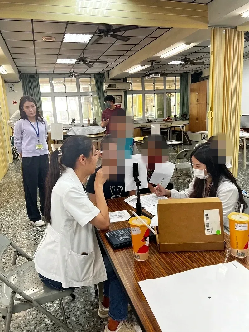 A professional assesses a student's binocular vision at school